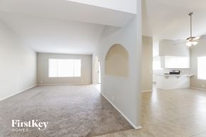 Glendale house for rent - A spacious, empty room with a rug on the floor and a ceiling fan.