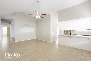 Glendale house for rent - A spacious room with a fan and a kitchen area in the background.