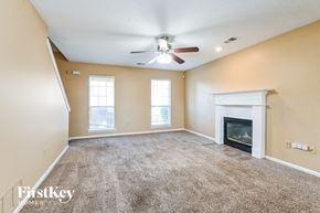 Walls house for rent - an empty living room with a fireplace and a ceiling fan