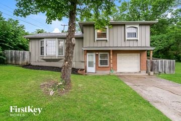 Raytown house for rent - a small gray house with a yard and a tree