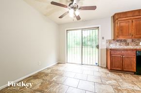Raytown house for rent - a kitchen and living room with a ceiling fan and a door
