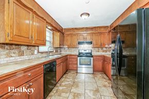 Raytown house for rent - a kitchen with wooden cabinets and stainless steel appliances