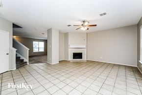 Fort Worth house for rent - an empty living room with a fireplace and a ceiling fan
