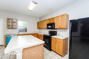 Fort Worth house for rent - a kitchen with black appliances and wooden cabinets