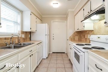 Humble house for rent - a kitchen with white appliances and white cabinets