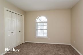Humble house for rent - a bedroom with carpet and a window and a white door