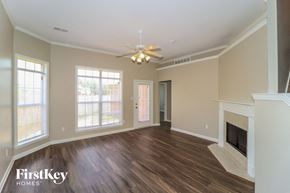 Cordova house for rent - A spacious living room with wood flooring and a fireplace.