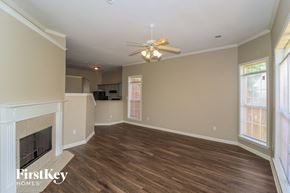 Cordova house for rent - A spacious living room with a fireplace and a ceiling fan.