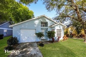 Orlando house for rent - a blue house with a white garage door and a lawn