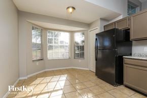 Orlando house for rent - a kitchen with a black refrigerator and a window