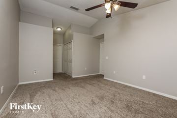 Orlando house for rent - a spacious living room with carpet and a ceiling fan