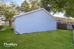 Orlando house for rent - the side of a white house in a yard with grass