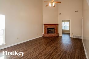 Southaven house for rent - A spacious room with a fireplace and a ceiling fan.
