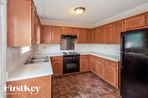 Southaven house for rent - A kitchen with wooden cabinets and a black refrigerator.