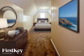 Southaven house for rent - A bedroom with a large bed and a painting of a coastline on the wall.