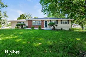 Kansas City house for rent - a house with a lawn and trees in front of it