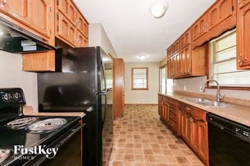 Kansas City house for rent - a kitchen with black appliances and wooden cabinets