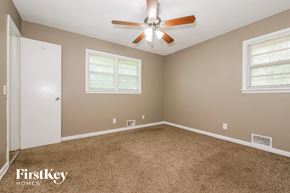 Kansas City house for rent - a bedroom with carpet and a ceiling fan