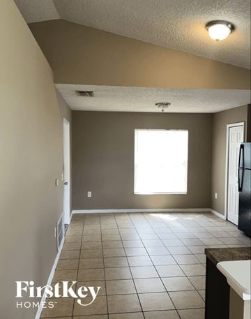Orlando house for rent - A kitchen with a tile floor and a refrigerator.
