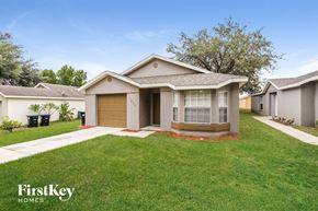 Orlando house for rent - a small house with a lawn and a driveway