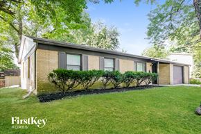 Indianapolis house for rent - a small brick house with a lawn and some bushes