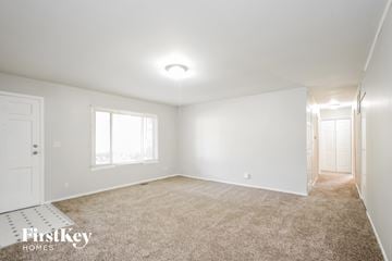 Indianapolis house for rent - a spacious living room with carpet and white walls