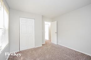 Indianapolis house for rent - a bedroom with white walls and carpet and a door to a closet