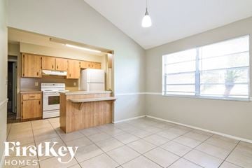 Lakeland house for rent - A kitchen with wooden cabinets and a white refrigerator is shown.