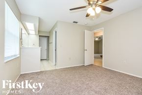 Lakeland house for rent - A spacious room with a ceiling fan and a carpeted floor.