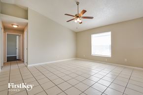 Orlando house for rent - an empty living room with a ceiling fan and tiled floors