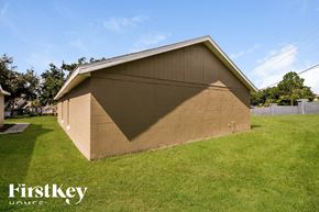 Orlando house for rent - the back of a brick garage with a shadow on the side of the grass