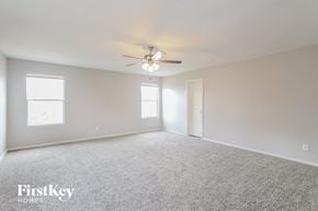 San Antonio house for rent - A spacious room with a ceiling fan and two windows.