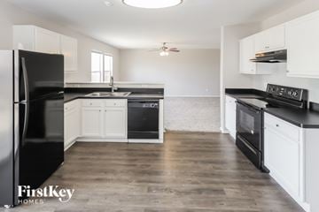 San Antonio house for rent - A kitchen with black appliances and white cabinets.