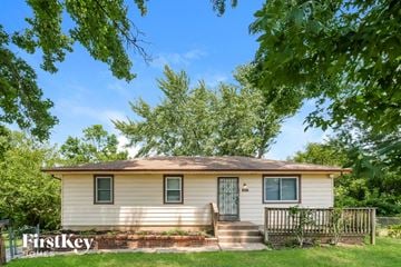 Kansas City house for rent - a small white house with a fence and some trees