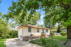 Kansas City house for rent - a small white house with a fence and trees