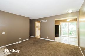 Kansas City house for rent - an empty living room with carpet and a door to the kitchen