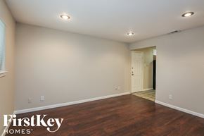 Dallas house for rent - a living room with wood flooring and white walls and a white door