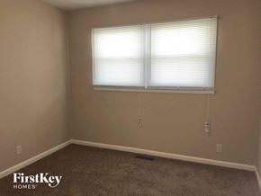 Indianapolis house for rent - a room with a window and a carpeted floor