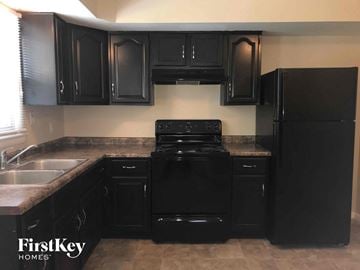 Indianapolis house for rent - a kitchen with black appliances and black cabinets