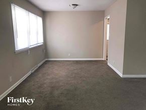 Indianapolis house for rent - an empty room with a carpeted floor and a window