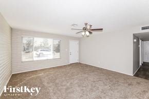 Phoenix house for rent - A room with a carpeted floor, a ceiling fan, and a window with blinds.