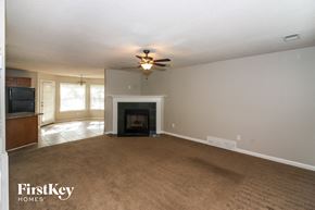 Walls house for rent - A living room with a fireplace and a ceiling fan.