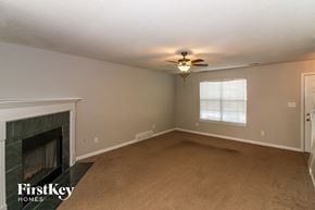 Walls house for rent - A room with a fireplace and a fan on the ceiling.