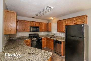 Walls house for rent - A kitchen with wooden cabinets and granite countertops.