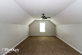 Walls house for rent - A spacious room with a ceiling fan and a window.