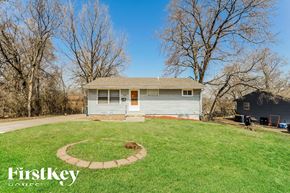 Kansas City house for rent - A house with a well-maintained lawn and a circular garden bed in the front yard.