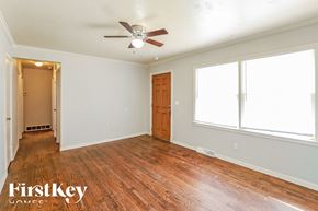 Kansas City house for rent - A room with wooden floors and a ceiling fan.