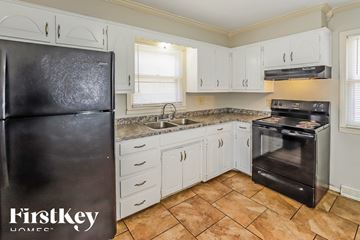 Kansas City house for rent - A kitchen with a black fridge and a black oven.
