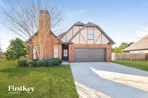 Mccalla house for rent - A brick house with a garage door and a chimney.
