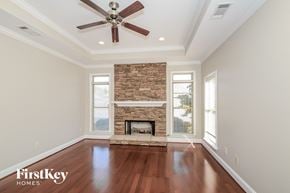 Mccalla house for rent - A spacious room with a fireplace and a ceiling fan.